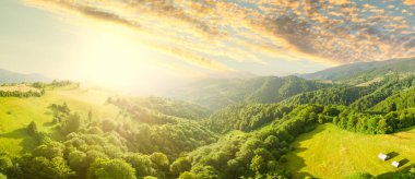 Karpatlar 'ın uçsuz bucaksız otlaklarının ve tarım arazilerinin havadan görünüşü. Tarım tarlası. Gün batımında kırsal dağ manzarası. Ukrayna.