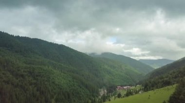 Dağ zirveleri ve sabah bulutları pürüzsüz hareket ediyor. Karpat Dağları 'nın çayırlarındaki yaz manzaralı vadi ağaçları. Ukrayna.