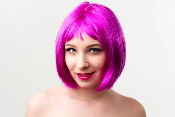 Volto di una giovane donna con trucco luminoso su sfondo rosa con capelli raccolti in una coda di cavallo liscia. — Foto Stock