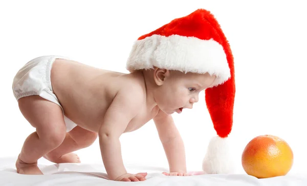 Bambino adorabile è seduto sul pavimento, indossa il cappuccio rosso di Natale, isolato su bianco — Foto Stock