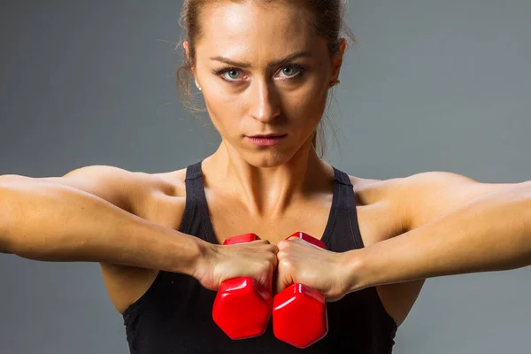 Красивая молодая кавказская фитнесс-женщина, тренирующаяся с тяжестью рук, вытянутыми руками . — стоковое фото