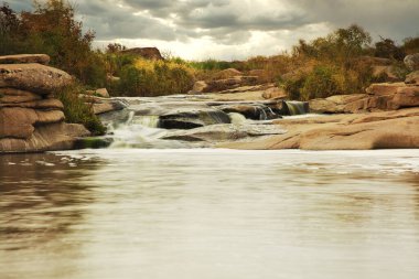 Kayaların üzerinden akan güzel dağ nehri. Dağ nehrinde akan su, yaklaş.