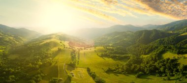 Karpatlar 'ın uçsuz bucaksız otlaklarının ve tarım arazilerinin havadan görünüşü. Tarım tarlası. Gün batımında kırsal dağ manzarası. Ukrayna.