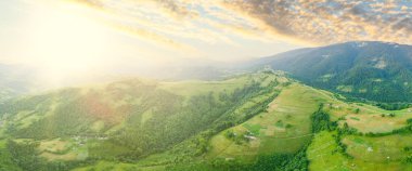 Karpatlar 'ın uçsuz bucaksız otlaklarının ve tarım arazilerinin havadan görünüşü. Tarım tarlası. Gün batımında kırsal dağ manzarası. Ukrayna.