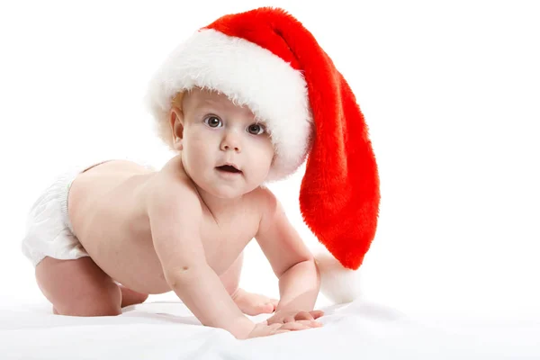 Bambino adorabile è seduto sul pavimento, indossa il cappuccio rosso di Natale, isolato su bianco — Foto Stock