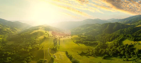 Karpatlar 'ın uçsuz bucaksız otlaklarının ve tarım arazilerinin havadan görünüşü. Tarım tarlası. Gün batımında kırsal dağ manzarası. Ukrayna.