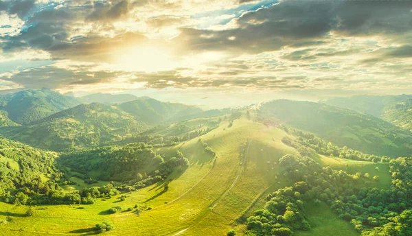 Vista aérea das pastagens exuberantes intermináveis das extensões dos Cárpatos e das terras agrícolas. Campo agrícola cultivado. Paisagem montanhosa rural ao pôr do sol. Ucrânia. — Fotografia de Stock