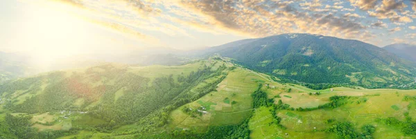 Widok z lotu ptaka na niekończące się pastwiska Karpat i pola uprawne. Uprawa pól rolnych. Krajobraz górski o zachodzie słońca. Ukraina. — Zdjęcie stockowe