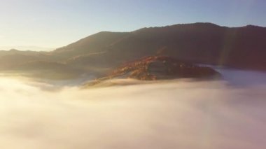 Yağmurdan sonra dağda hareket eden bir bulutun harika hissi. Güneş doğarken bulutların üstünde uçmak, bir drondan bulutların ve dağların en üst görüntüsü. Karpatlar, Synevyr geçidi, Ukrayna.