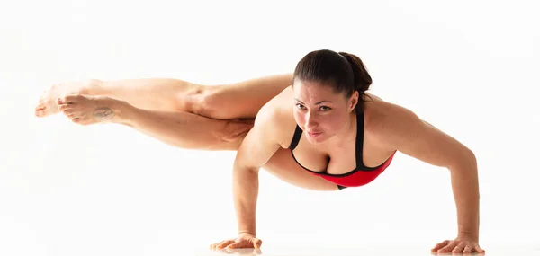 Deportiva hermosa mujer joven practicando yoga, haciendo ejercicio de embestida, Rotved Side Angle Pose,, haciendo ejercicio usando ropa deportiva roja y negra, estudio de larga duración, fondo blanco aislado. — Foto de Stock