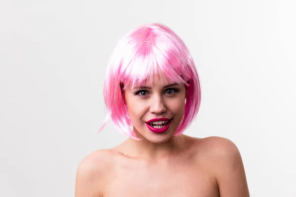 Rosto de uma jovem mulher com maquiagem brilhante em um fundo rosa com cabelo reunido em um rabo de cavalo liso. — Fotografia de Stock
