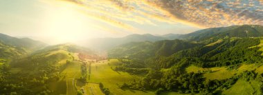 Karpatlar 'ın uçsuz bucaksız otlaklarının ve tarım arazilerinin havadan görünüşü. Tarım tarlası. Gün batımında kırsal dağ manzarası. Ukrayna.