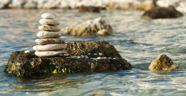 Muhteşem doğa. Kırım yarımadasında bir sürü parlak taş yığılmış ve cilalanmış taşlar. Arka plan deniz, diğer adalarla birlikte çakıl taşı plajı..