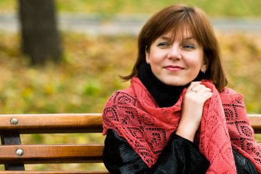 Şık, çekici, genç bir kadın sonbahar kıyafetiyle caddede yürüyor, kırmızı örgü eşarp, mutlu ruh hali, moda tarzı..