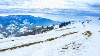 Karla kaplı dağ zirvesi rüzgarla esiyor. Kış manzarası. Soğuk bir gün, karlı..