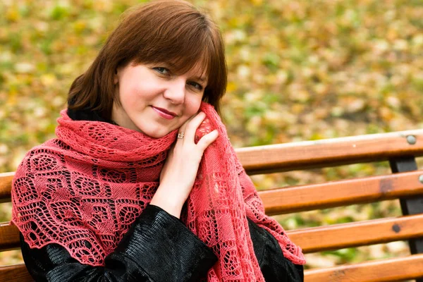 Şık, çekici, genç bir kadın sonbahar kıyafetiyle caddede yürüyor, kırmızı örgü eşarp, mutlu ruh hali, moda tarzı..