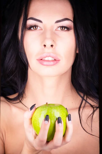 Απόκριες. Μια τρομερή κακιά μάγισσα κρατά ένα δηλητηριασμένο μήλο στα χέρια της, στέκεται στη φωλιά της ανάμεσα στους ιστούς αράχνης. Σατανική μαύρη μαγεία. Royalty Free Εικόνες Αρχείου