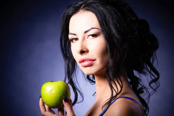 Απόκριες. Μια τρομερή κακιά μάγισσα κρατά ένα δηλητηριασμένο μήλο στα χέρια της, στέκεται στη φωλιά της ανάμεσα στους ιστούς αράχνης. Σατανική μαύρη μαγεία. Εικόνα Αρχείου