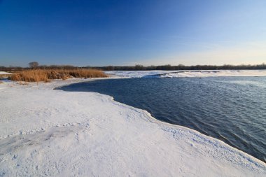 Donmuş gölü ve günbatımı gökyüzü olan güzel bir kış manzarası. Doğanın bileşimi.