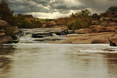 Kayaların üzerinden akan güzel dağ nehri. Dağ nehrinde akan su, yaklaş.