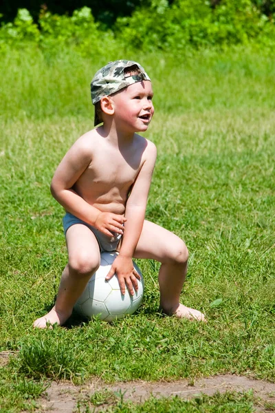 Atletik çocuk. Parkta futbol oynayan mutlu küçük çocuk. Çocuklar futbol oynuyor. Aile eğlencesi..