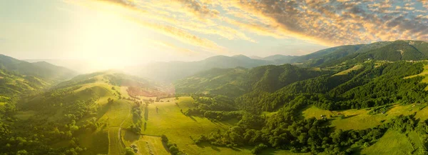 Karpatlar 'ın uçsuz bucaksız otlaklarının ve tarım arazilerinin havadan görünüşü. Tarım tarlası. Gün batımında kırsal dağ manzarası. Ukrayna.