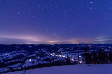 Şehrin sokaklarında gece gökyüzü arka planda parlak ışıkları. Panoramik yerleşim alanları.