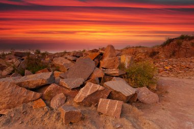 Ukrayna 'da granit madeninde kayalar ve ön planda büyük taşlar bulunan bir çöl manzarası..