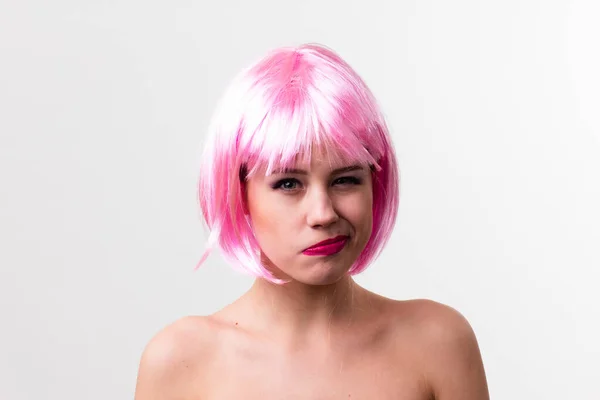 Twarz młodej kobiety z jasnym makijażem na różowym tle z zebranymi włosami w gładkim kucyku. — Zdjęcie stockowe