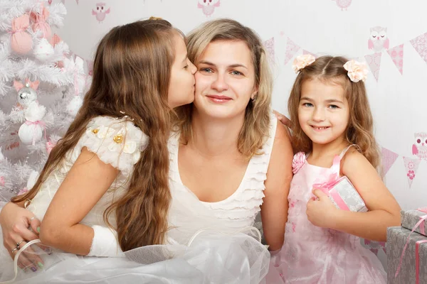 Mother together in the little daughter, sit on a floor near a festive fir-tree, play and consider gifts. Waiting for a holiday — Stock Photo, Image