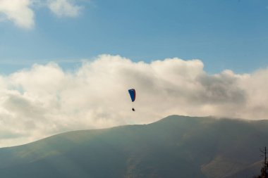 Yaz günü bulutlar üzerinde uçan Yamaçparaşütü
