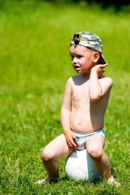 Atletik çocuk. Parkta futbol oynayan mutlu küçük çocuk. Çocuklar futbol oynuyor. Aile eğlencesi..