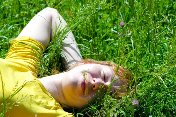 Yeşil çimlerin üzerinde uzanan ve dinlenen güzel sağlıklı genç kadın, konu bulanıklaşıyor.