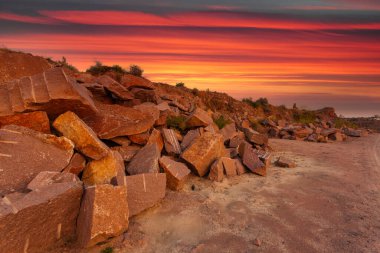 Ukrayna 'da granit madeninde kayalar ve ön planda büyük taşlar bulunan bir çöl manzarası..