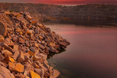 Ukrayna 'da granit madeninde kayalar ve ön planda büyük taşlar bulunan bir çöl manzarası..