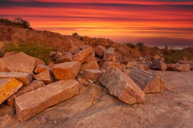Ukrayna 'da granit madeninde kayalar ve ön planda büyük taşlar bulunan bir çöl manzarası..