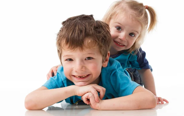 Portrait of a brother and sister, curly blond with blue eyes laughing merrily on a white background. Childrens emotions, happiness, joy, fun. Beautiful cute children. Friendship. — Fotografia de Stock