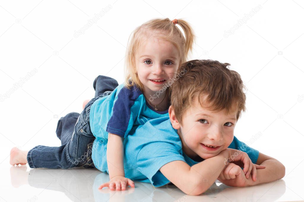 Portrait of a brother and sister, curly blond with blue eyes laughing merrily on a white background. Childrens emotions, happiness, joy, fun. Beautiful cute children. Friendship.