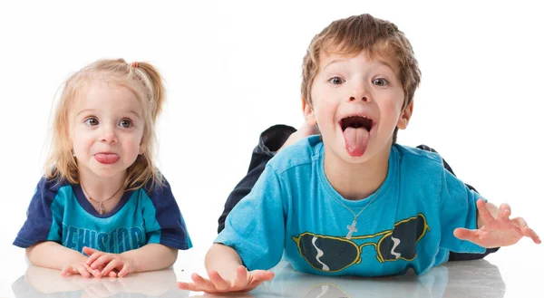 Portrait d'un frère et d'une sœur, blonds bouclés aux yeux bleus riant joyeusement sur fond blanc. Enfant émotions, bonheur, joie, plaisir. Beaux enfants mignons. Amitié. — Photo