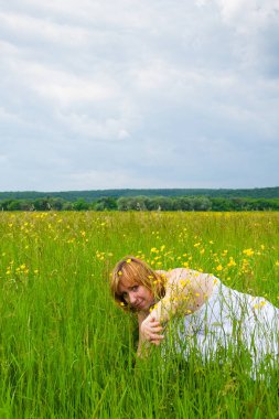 Düğün günü, güzellik, doğa konsepti. Tarlanın ortasında beyaz gelinlik giyen harika bir kadın var. Kendi etrafında dönüyor ve pullar güneşin ışığında parlıyor.