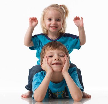 Bir erkek ve kız kardeşin portresi, mavi gözlü kıvırcık sarışın beyaz arka planda neşeyle gülüyor. Çocuksu duygular, mutluluk, neşe, eğlence. Güzel şirin çocuklar. Arkadaşlık..