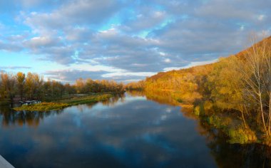 Sonbaharda göl kenarında gün doğumu, yükselen güneşin arka ışığında göl, sonbahar ve sonbaharda park sabah güneş ışığında park, suda renkli yapraklar, sonbaharda suyun yanında ağaçlar.