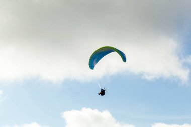 Yaz günü bulutlar üzerinde uçan Yamaçparaşütü