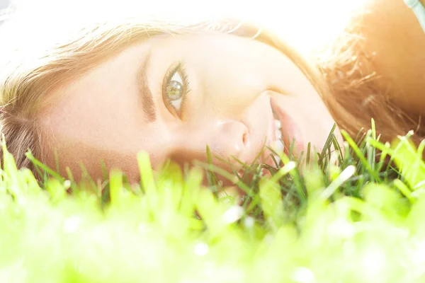 Linda chica morena con vestido elegante relajante al aire libre en hierba verde y huele a limón aromático o cítricos de lima — Foto de Stock