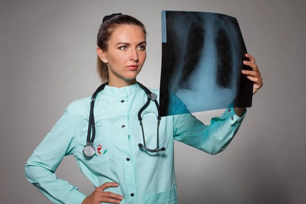 Giovane bella donna medico bruna indossa stetoscopio tenendo radiografia del torace con un viso felice in piedi e sorridente con un sorriso fiducioso che mostra i denti — Foto Stock