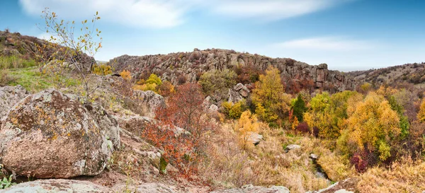Um grande número de minerais de pedra cobertos com vegetação verde situada acima de um pequeno rio na pitoresca Ucrânia e sua bela natureza — Fotografia de Stock