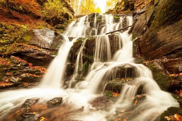 Ukpaine. Wasserfall zwischen den bemoosten Felsen. Schöne Stromschnellen an einem Gebirgsfluss im Herbstwald in den Karpaten bei Sonnenuntergang. Silberfluss im Shypit Carpat Nationalpark. Pilipets. — Stockfoto