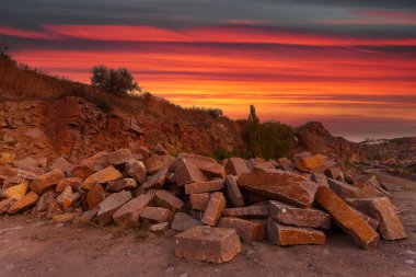 Ukrayna 'da granit madeninde kayalar ve ön planda büyük taşlar bulunan bir çöl manzarası..