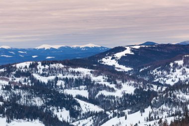 Dağlar ve ormanlarla çevrili mavi gökyüzü ile Slavske kayak yamacı. Karpat Dağları, Ukrayna. 