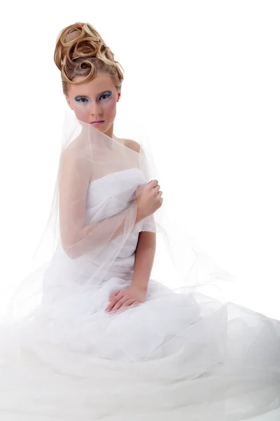 The girl with long hair in a light, white dress posing on light grey background. Studio shot,isolated image. — Stock Photo, Image